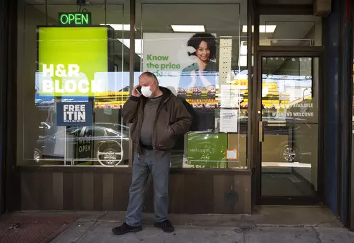 A man waits outside a H&R Block tax preparation office on Monday, April 6, 2020, in the Brooklyn borough of New York. Tax season is here again. Whether you do your taxes by yourself, go to a tax clinic or hire a professional, navigating the tax system can be complicated. (AP Photo/Mark Lennihan, File)