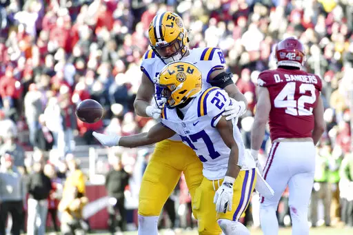 LSU running back Josh Williams (27) celebrates with teammate Mason Taylor (86) after scoring a touchdown against Arkansas during the second half of an NCAA college football game Saturday, Nov. 12, 2022, in Fayetteville, Ark. (AP Photo/Michael Woods)