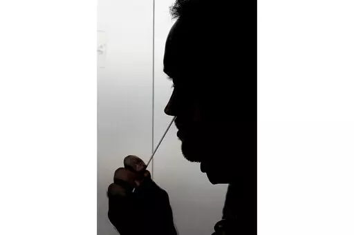 FILE - A rapid COVID-19 test is taken, Wednesday, Nov. 18, 2020, in Salt Lake City. President Joe Biden says the federal government will buy half a billion COVID-19 rapid test kits and distribute them free of charge to people to use at home. Delivery of the first batch of the 500 million tests isn't expected until early January 2022. (AP Photo/Rick Bowmer, File)