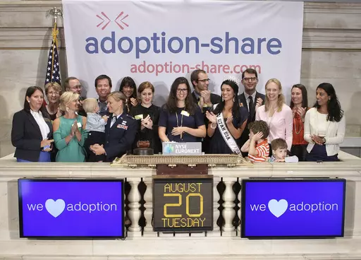In this photo provided by the New York Stock Exchange, Adoption-Share founder and CEO Thea Ramirez, center, Miss Utah USA 2013 Marissa Powell, center right, and fellow adoption supporters ring the opening bell at the New York Stock Exchange in New York on Aug. 20, 2013. An Associated Press investigation found that Adoption-Share’s tool known as Family-Match – among the few adoption algorithms on the market in 2023 – has produced limited results in the states where it has been used, accordi