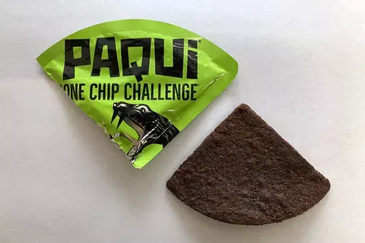 A Paqui One Chip Challenge chip is displayed in Boston, Friday, Sept. 8, 2023. A medical examiner says a Massachusetts teen who participated in a spicy tortilla chip challenge died from ingesting a substance “with a high capsaicin concentration,” according to autopsy results The Associated Press obtained late Wednesday, May 15, 2024. Capsaicin is a chili pepper extract. Harris Wolobah died on Sept. 1, 2023, after eating the chip. (AP Photo/Steve LeBlanc, File)
