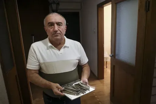Former dentist Nazim Valiyev shows his dental tools at his home in Baku, Azerbaijan, Saturday, Oct. 14, 2023. Valiyev is among the estimated 700,000 Azerbaijanis who fled or were forced out of the region amid violence that flared beginning in 1988 and then flared into an outright war that ended in 1994 with the region under the control of ethnic Armenian forces supported by Armenia. (AP Photo/Aziz Karimov)