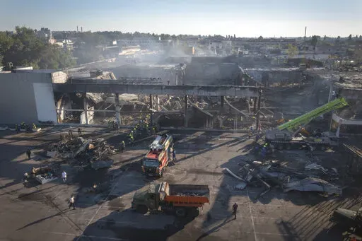 Ukrainian State Emergency Service firefighters work to take away debris at a shopping center burned after a rocket attack in Kremenchuk, Ukraine, Tuesday, June 28, 2022. Residents of the quiet, riverside city of Kremenchuk are reeling in the wake of a Russian airstrike that obliterated a shopping mall and killed at least 18. With dozens still missing, psychologists are working with families to help them through their grief and toward acceptance that they may never find their loved ones. (AP Phot