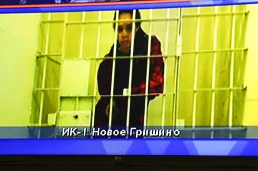WNBA star and two-time Olympic gold medalist Brittney Griner is seen on the bottom part of a TV screen as she waits to appear in a video link provided by the Russian Federal Penitentiary Service a courtroom prior to a hearing at the Moscow Regional Court in Moscow, Russia, Tuesday, Oct. 25, 2022. A Russian court on Tuesday started hearing American basketball star Brittney Griner's appeal against her nine-year prison sentence for drug possession. (AP Photo/Alexander Zemlianichenko)