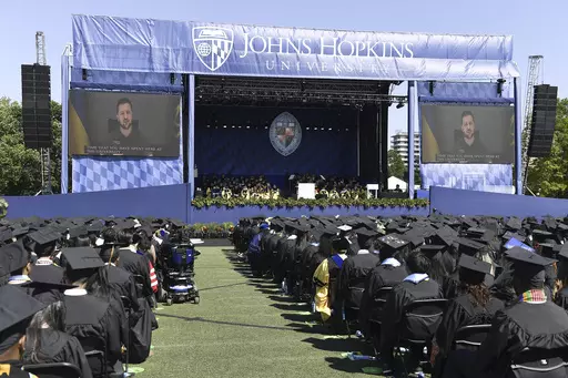 In this handout photo released by Johns Hopkins University, Ukrainian President Volodymyr Zelenskyy addresses the graduating class of Johns Hopkins University via livestream from Ukraine, Thursday, May 25, 2023, in Baltimore, Md. (Will Kirk/Johns Hopkins University via AP)