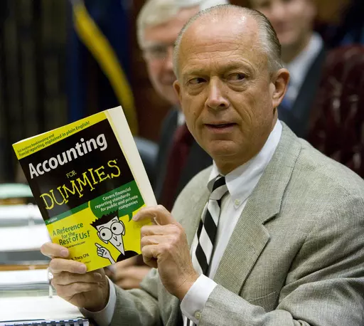 South Carolina Comptroller General Richard Eckstrom holds up a book he wanted to present to his new Chief of Staff James Holly during his introduction at the Budget and Control Board meeting, Aug. 13, 2009, in Columbia, S.C. Pressure is mounting for Eckstrom after a $3.5B accounting error. (AP Photo/Mary Ann Chastain, File)