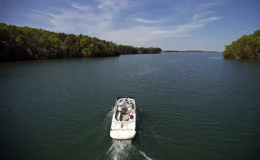 A boat passes along Lake Lanier, April 23, 2013, in Buford, Ga. Fashion designer Tameka Foster, the ex-wife of R&B singer Usher, is calling to drain Lake Lanier, Georgia's largest lake, where her son was fatally injured 11 years ago. Kile Glover, her 11-year-old son with Bounce TV chairman Ryan Glover, died in July 2012 after a personal watercraft struck the boy as he floated in an inner tube on the lake. (AP Photo/David Goldman, File)