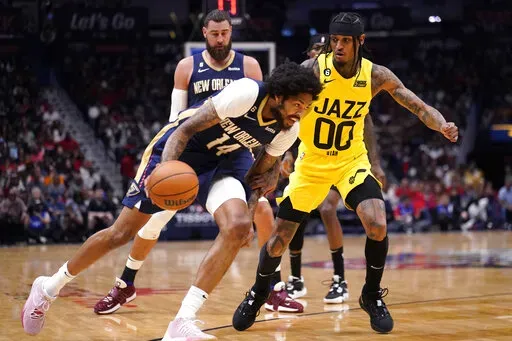 New Orleans Pelicans forward Brandon Ingram (14) drives to the basket against Utah Jazz guard Jordan Clarkson (00) in the first half of an NBA basketball game in New Orleans, Sunday, Oct. 23, 2022. (AP Photo/Gerald Herbert)