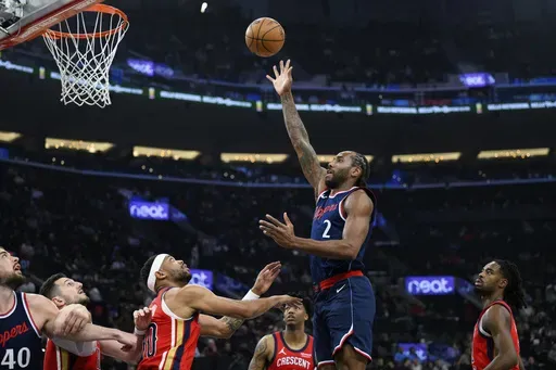 Los Angeles Clippers forward Kawhi Leonard (2) shoots over New Orleans Pelicans forward Bruce Brown, center, during the first half of an NBA basketball game Wednesday, April 2, 2025, in Inglewood, Calif. (AP Photo/William Liang)