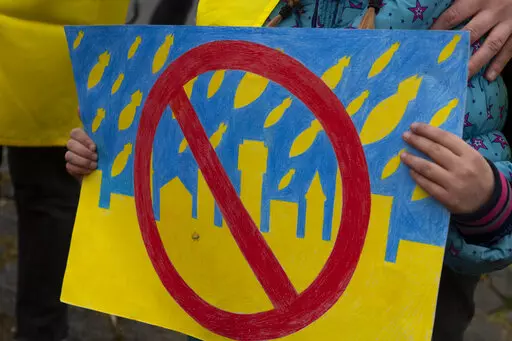 A child holds a drawing as she and others demonstrate in support of the Ukraine outside the United Nations' top court in The Hague, Netherlands, Wednesday, March 16, 2022, where judges where expected to rule on a request by Ukraine to order Russia to halt its devastating invasion. But it remains to be seen if Moscow would comply with any order made by the International Court of Justice. Russia snubbed a hearing last week at which lawyers for Ukraine accused the country's powerful neighbor of "re