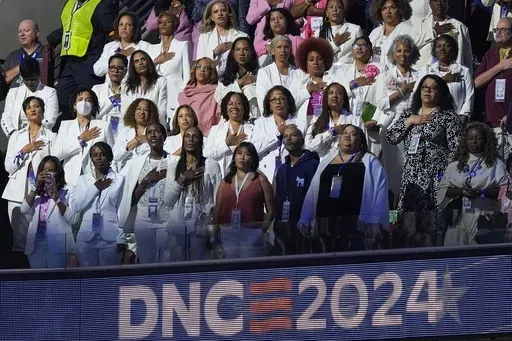 People wear white during the Pleadge of Alliegence during the Democratic National Convention Thursday, Aug. 22, 2024, in Chicago. (AP Photo/Charles Rex Arbogast)