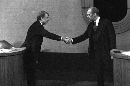 Jimmy Carter, left, and Gerald Ford, right, shake hands before the third presidential debate, Oct. 22, 1976, in Williamsburg, Va. (AP Photo/File)